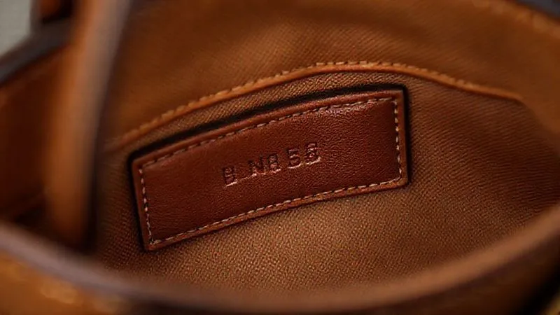 A close-up, high-detail photorealistic image of a vintage designer handbag's interior, showing a clear, embossed serial number and a brand label with meticulous stitching. Cinematic lighting, sharp focus on the details, depth of field blurring the rest of the bag, 8K, professional photography, shot on a high-end DSLR.