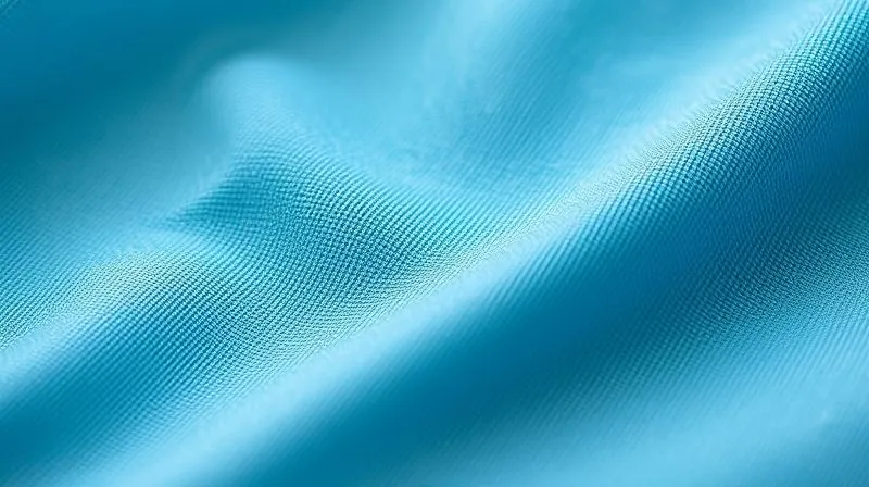 A close-up, photorealistic, professional photography, 8K image of a perfectly executed flatlock seam on a vibrant, soft blue fabric. The seam is almost imperceptible, lying completely flat against the textile, showcasing the meticulous stitching detail. Cinematic lighting highlights the texture, sharp focus, depth of field. Shot on a high-end DSLR.