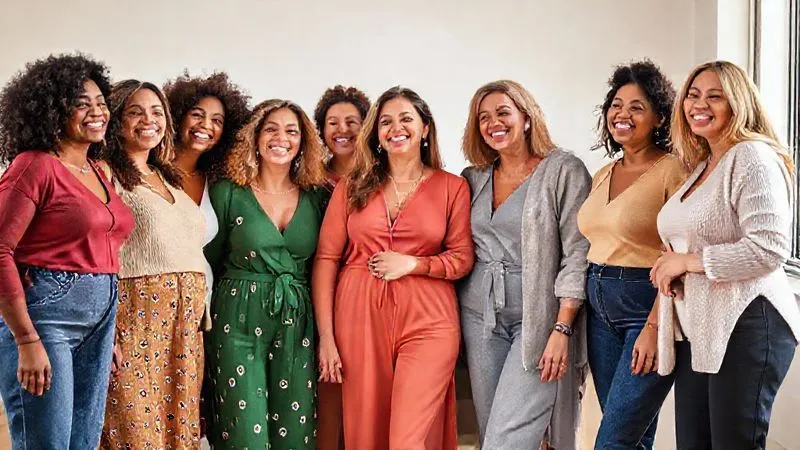 A diverse group of women of all ages and body shapes, smiling confidently and interacting naturally, dressed in a collection of inclusive and flattering womenswear. The setting is bright and uplifting, emphasizing joy and self-acceptance. Photorealistic, professional photography, 8K, cinematic lighting, sharp focus, depth of field, shot on a high-end DSLR.
