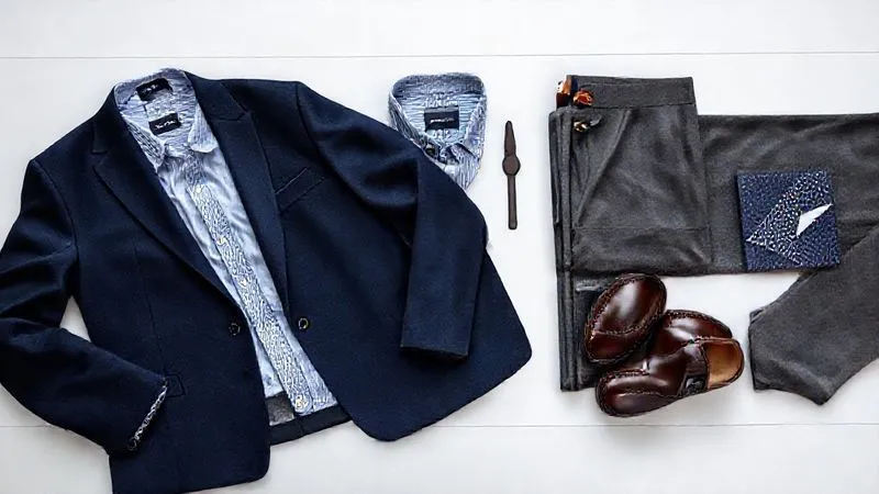 photorealistic, professional photography, 8K, cinematic lighting, sharp focus, depth of field, shot on a high-end DSLR. A flat lay composition showcasing a curated executive business casual wardrobe for a man. Items include a navy wool blazer, a light blue Oxford shirt, charcoal grey tailored trousers, a pair of dark brown leather penny loafers, a minimalist leather watch, and a subtly patterned silk pocket square. The arrangement is elegant and clean, emphasizing quality and coordination.