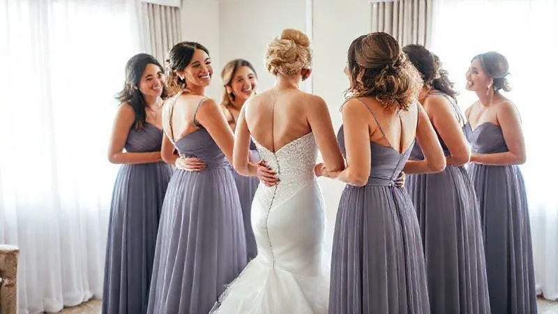 A heartwarming, photorealistic image of a group of bridesmaids laughing and adjusting their dresses during a pre-wedding dress rehearsal, showcasing camaraderie and perfectly fitted gowns. The scene is bright and joyful, with natural light, 8K, professional photography, depth of field subtly blurring the background.